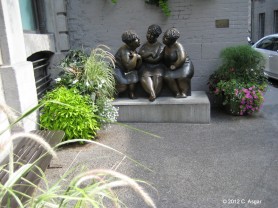 These are three ladies having an interesting conversation.These are statues in front of the building.